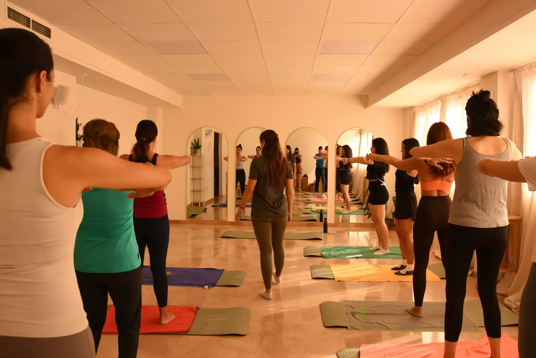 Classe de moviment en grup sobre estores en una sala lluminosa