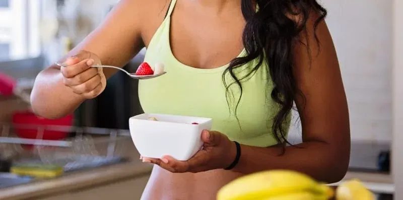 Persona menjant fruita fresca en un esmorzar saludable